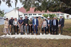 Tossing dirt to celebrate the construction of a new private fiber network for the school district were: Cindy Forsyth (from left), Jay Duval, Denise Weybrew, Hope Jernigan, Todd Widergren, Dana Brady-Giddens, Patrick Mitchell, Keith Couey, Cherry Hill, Jesus Pena, Billy Merchant and Oliver Landow. (TONY BRITT/Lake City Reporter)