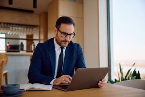 businessman-working-laptop-while-sitting-cafe